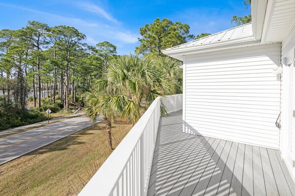A white building with a covered porch and a view of a road with trees and a palm tree. - ☀️Private Pool-4Bikes-4BR-30A-Endless Paradise (Santa Rosa Beach)