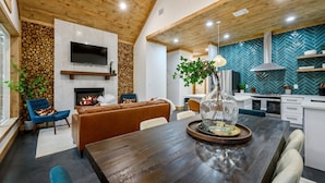 A modern kitchen with a herringbone tile backsplash, a built-in oven, and a stainless steel range hood. - Private Pond | Kayaks · Spa Bath | Romantic Cabin (Broken Bow)