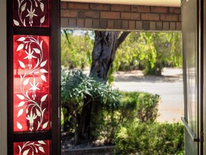 A view through a glass door with a red and white floral pattern.