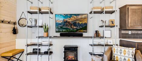 Una sala de estar con chimenea, estanterías de madera, televisor y sofá.