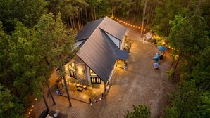 A house surrounded by trees with a deck and outdoor seating area.