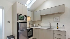 A modern kitchen with a built-in oven, microwave, and a skylight above the countertop. - 1 bedroom accommodation in Clitheroe (Clitheroe)