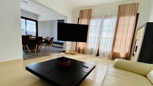 A modern living room with a black coffee table, a beige sofa, and a flat-screen TV. - Casa Pari Luxury (Playa Blanca)