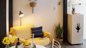 A dining area with a round table, white chairs, and a yellow sofa in the background. - Cozy loft with small pets allowed (Firenze)
