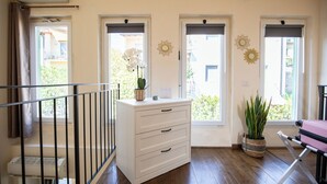 A room with a white dresser, a potted plant, a suitcase, and a balcony door. - Cozy loft with small pets allowed (Firenze)
