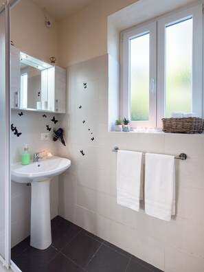 A bathroom with a white sink, mirror, and two towels hanging on a rack. - Cozy loft with small pets allowed (Firenze)