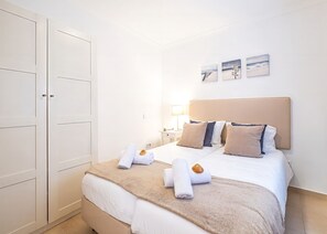 A hotel room with a bed, a nightstand, a lamp, and a wardrobe.