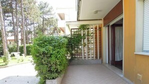 A residential property with a tiled entrance, a small garden, and a wooden fence.