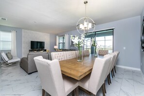 Enjoy meals together at the dining table surrounded by comfortable seating and a large window offering a view of the outdoors.