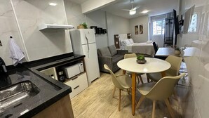 Una cocina moderna con comedor, que incluye una mesa redonda y sillas, un refrigerador y un microondas.