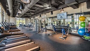 A gym with treadmills, weight machines, and exercise balls. - Last Minute Disney! Private Pool, Hot Tub, Game Room & Themed Bedrooms. Book Now! #20650 (Orlando)