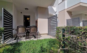 A small outdoor patio with two chairs and a table, surrounded by a low hedge and a gate. - Residenz Evanike Wohnung B2 1S Erdgeschoss M2 für 4 Personen (Bibione)
