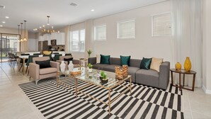 A modern living room with a sofa, coffee table, and dining area.
