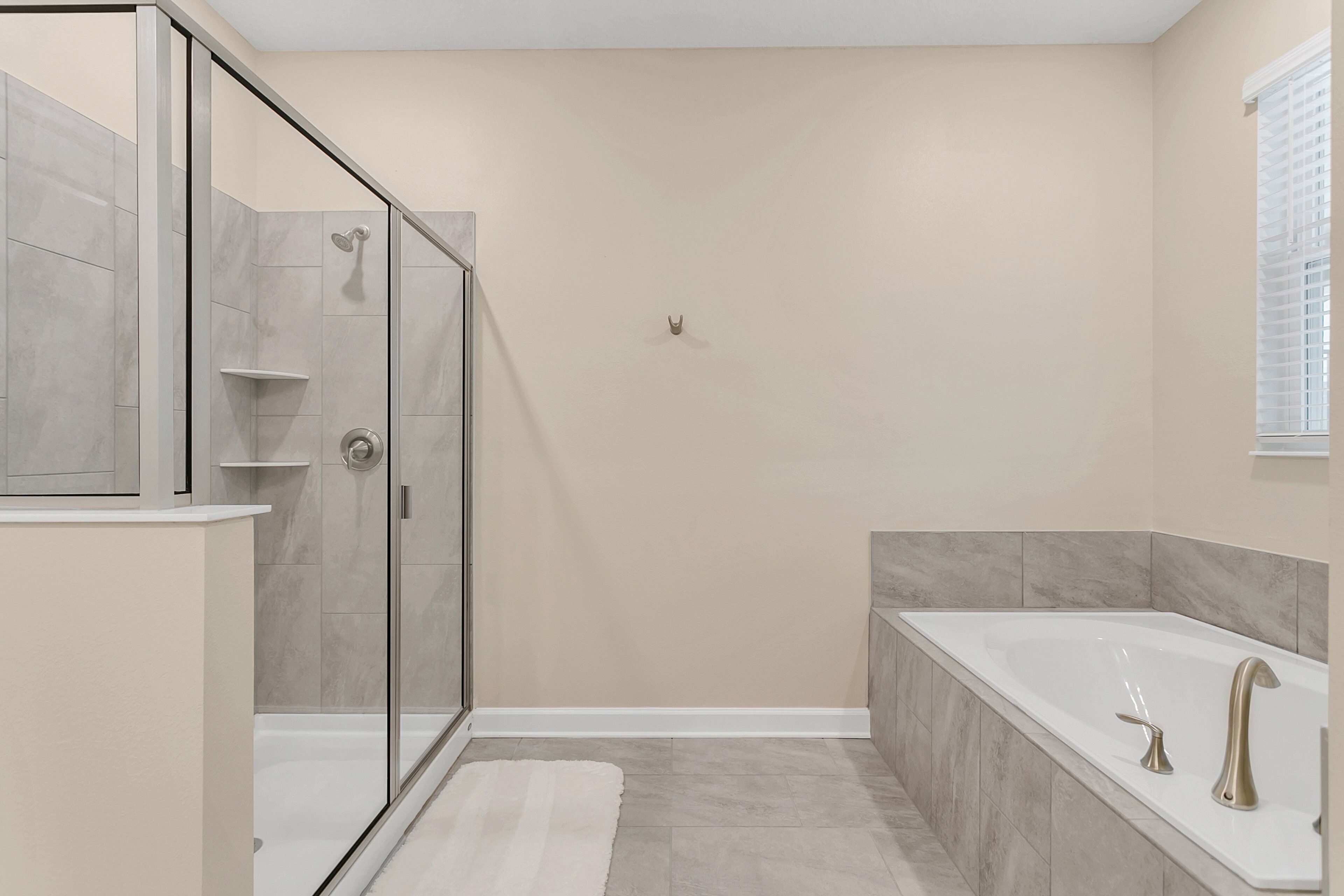 A modern bathroom with a glass-enclosed shower, a freestanding bathtub, and a vanity with a mirror.