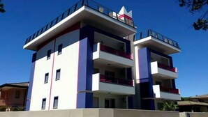 A multi-story building with balconies, a flat roof, and a distinct architectural design.