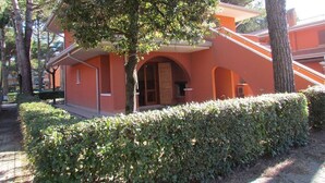 Ein Gebäude mit roter Fassade, Bogenfenstern und einem überdachten Gang.