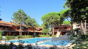 Ein Hotel mit Schwimmbad, umgeben von Pflanzen und Bäumen.