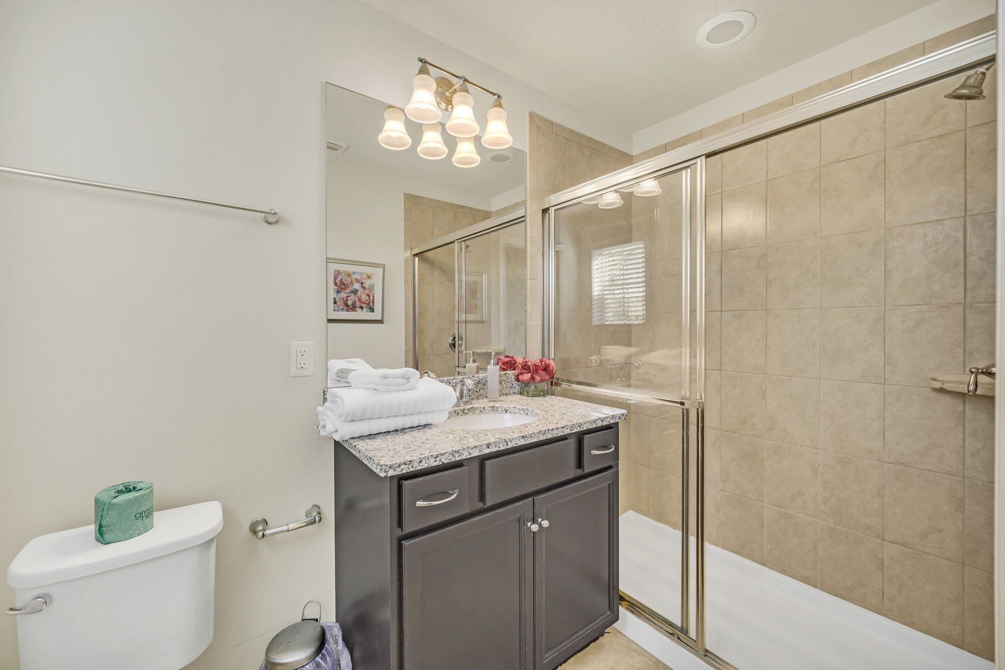 A bathroom with a toilet, sink, and shower.