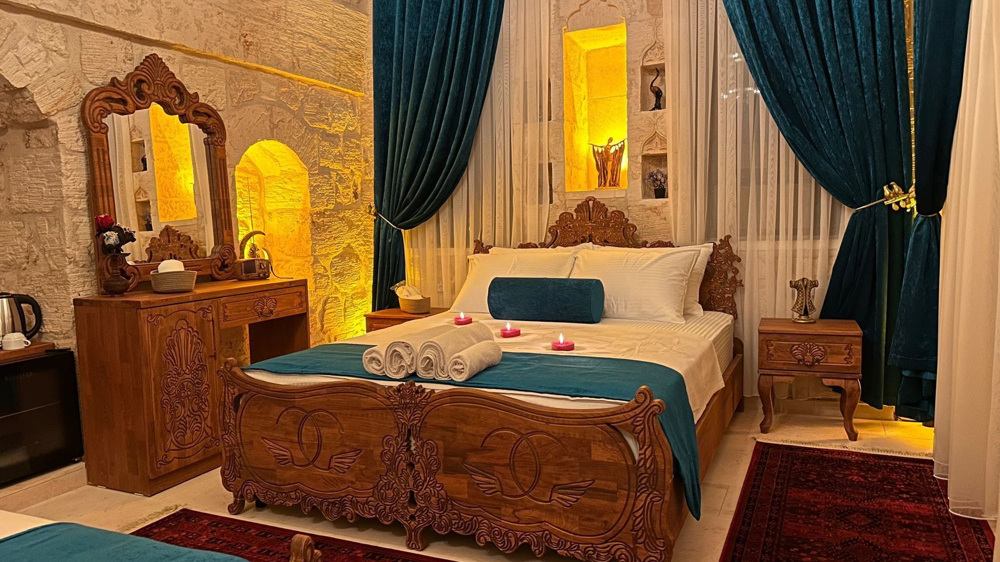 A bedroom with a wooden bed, a dresser, a mirror, and a nightstand.