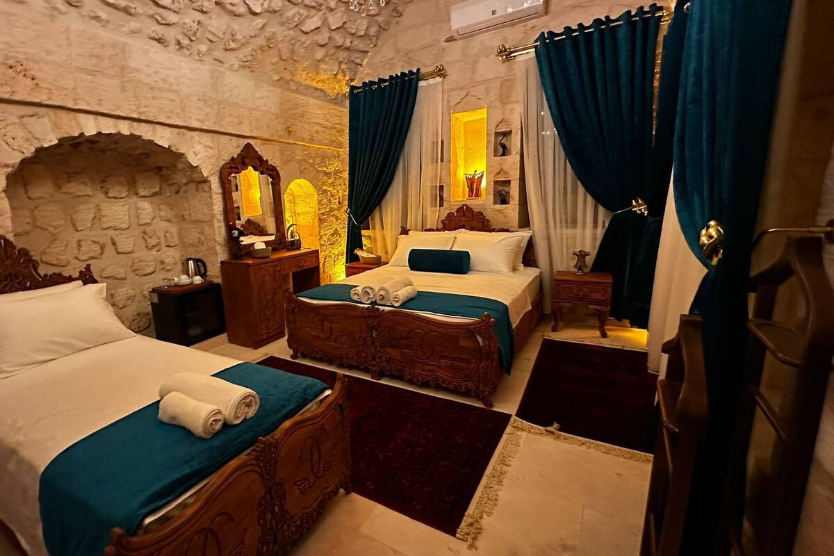 Een kamer met twee bedden, een stenen muur en een spiegel.