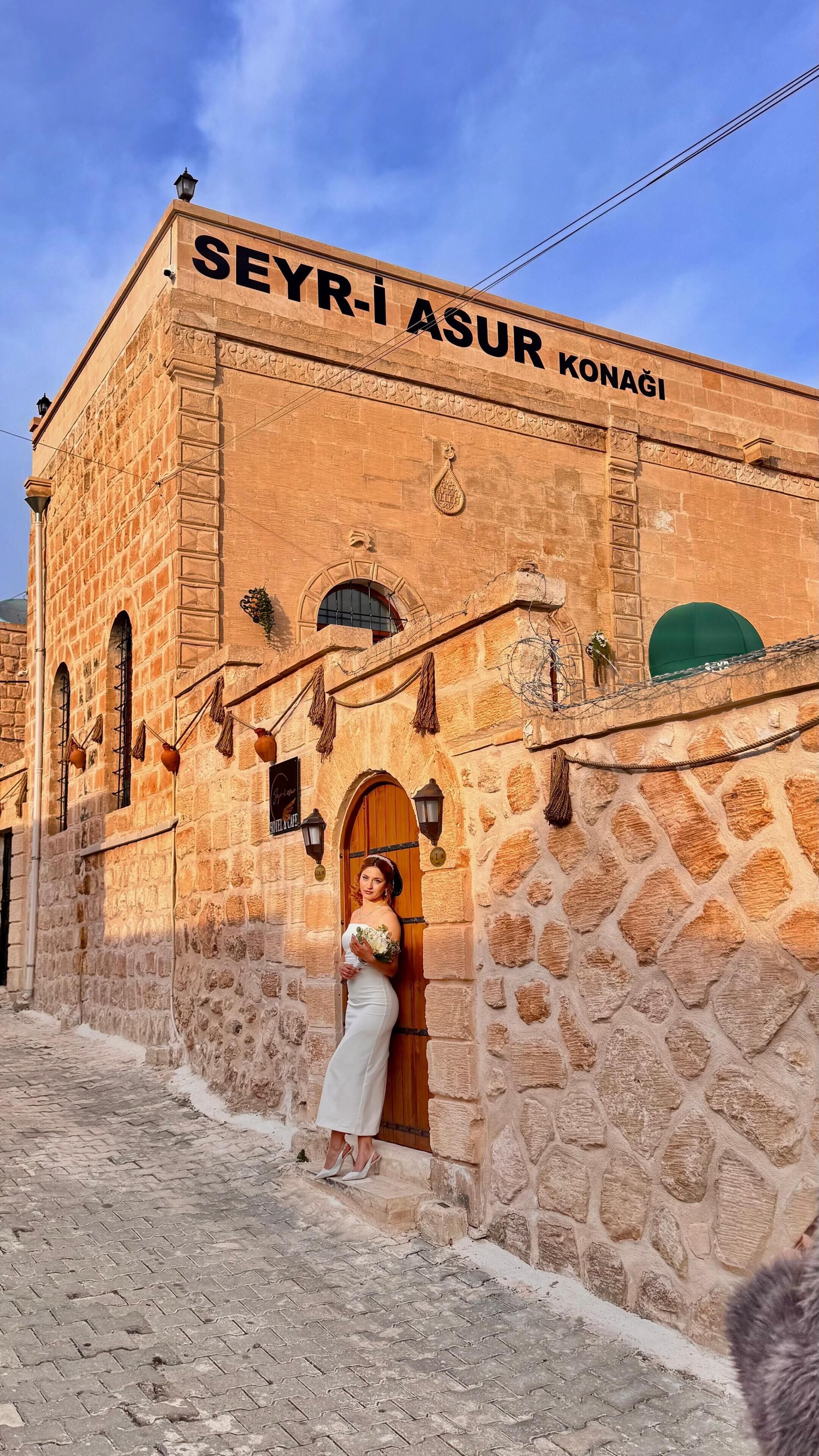 A stone building with the sign "SEYRI ASUR KONAGI".