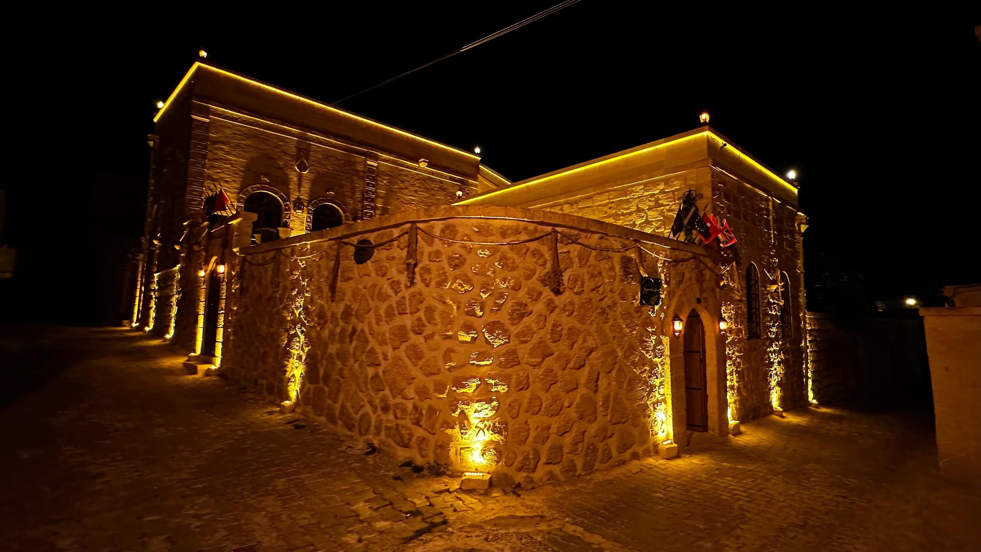 A stone building with a central courtyard, illuminated by warm lighting.