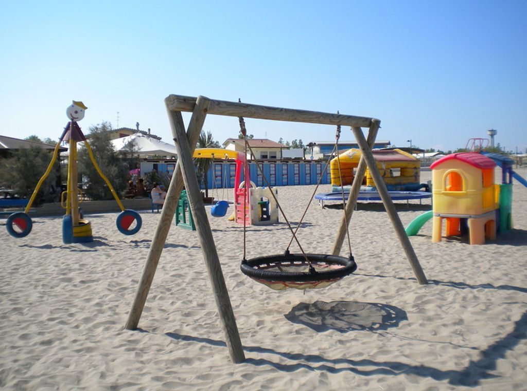 Een strand speeltuin met een schommel en een autobandschommel.