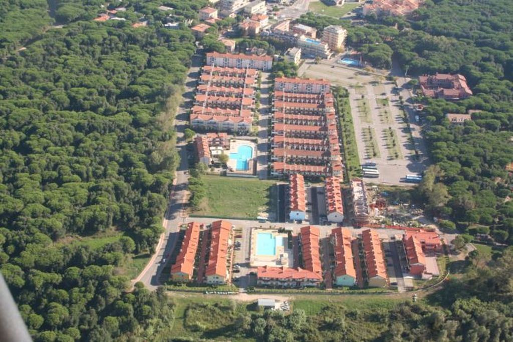 Eine Vogelperspektive eines Hotels mit mehreren Gebäuden, einem Swimmingpool und umgebender Bepflanzung.