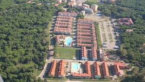 Eine Vogelperspektive eines Hotels mit mehreren Gebäuden, einem Swimmingpool und umgebender Bepflanzung.