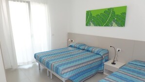 Una camera da letto con due letti, un comodino, una lampada e un'opera d'arte verde appesa al muro.