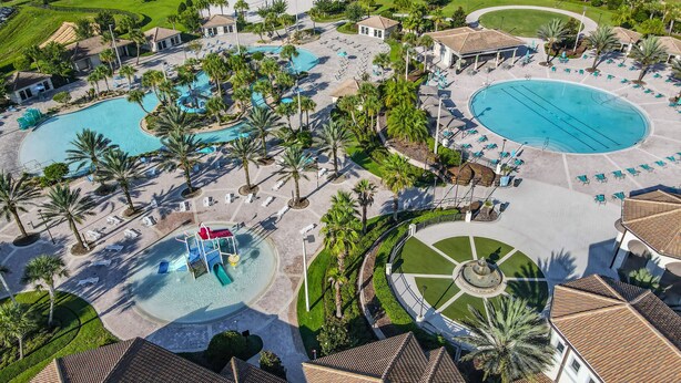 Vista aérea de un complejo turístico con múltiples piscinas, palmeras y zonas de descanso.