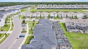 Una zona residencial con casas modernas, una carretera curva y un paisaje verde.
