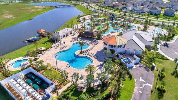 Ein Resort mit mehreren Schwimmbecken, einem großen See und Wohngebäuden.