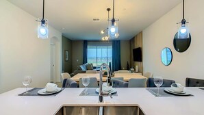 A modern hotel room with a dining area, a sofa set, a TV, and a large window offering a city view. - Last Minute Disney Getaway! Themed Bedrooms & Private Balcony. Book Now! #87993 (Orlando)