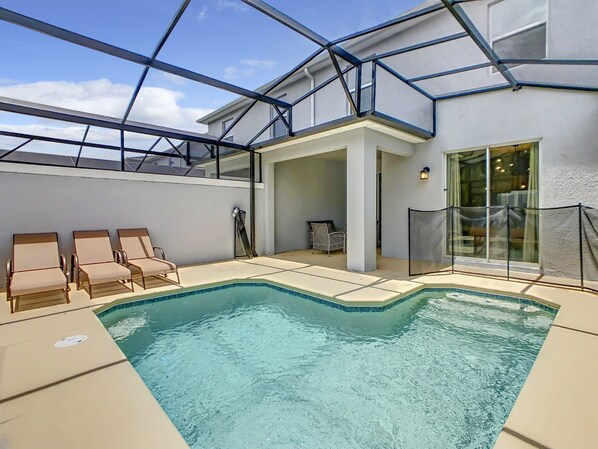 Piscina interna con poltrona a sdraio e area patio vetrata.