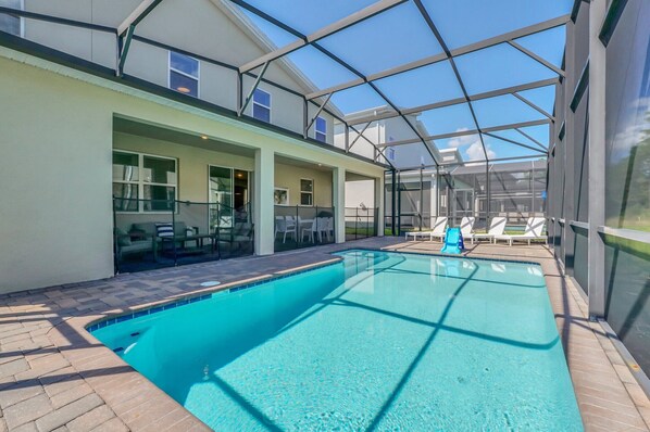 A swimming pool with a glass ceiling, lounge chairs, and a patio area. - Last Minute Disney! Private Pool, Hot Tub, Game Room & Themed Bedrooms. Book Now! #104309 (Orlando)