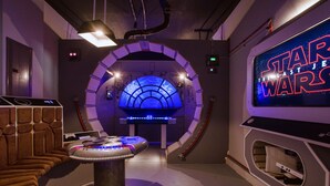 A Star Wars themed room with a large screen displaying 'Star Wars: The Last Jedi', a gaming console, and a futuristic seating area. - Last Minute Disney Getaway! Private Pool, Hot Tub & Game Room. Book Now! #108961 (Orlando)