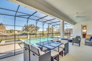 Ein überdachter Außenbereich mit Pool, Sitzgelegenheiten und Blick auf die umliegende Landschaft.