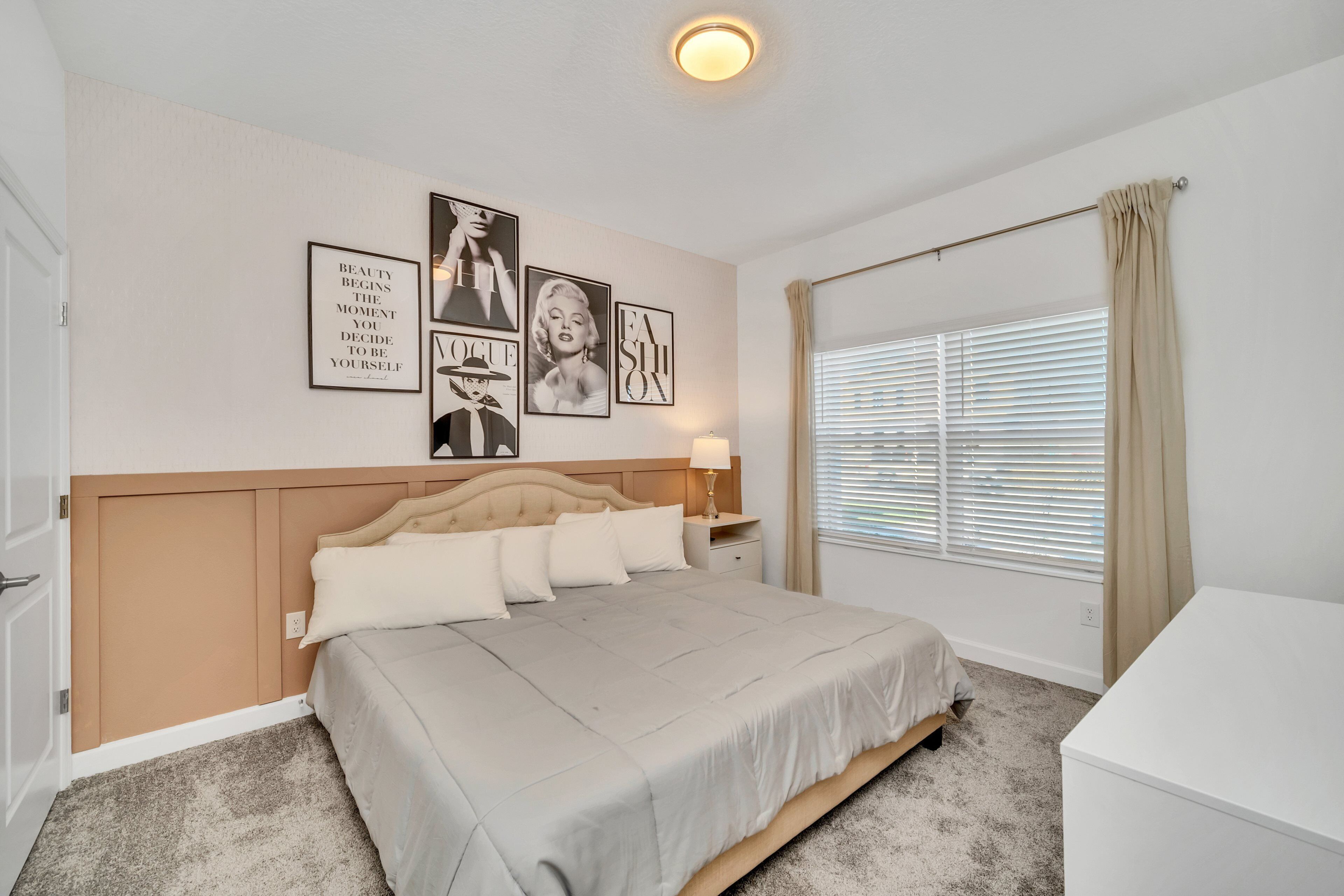A neatly arranged bedroom with a bed, bedside table, and wall art.