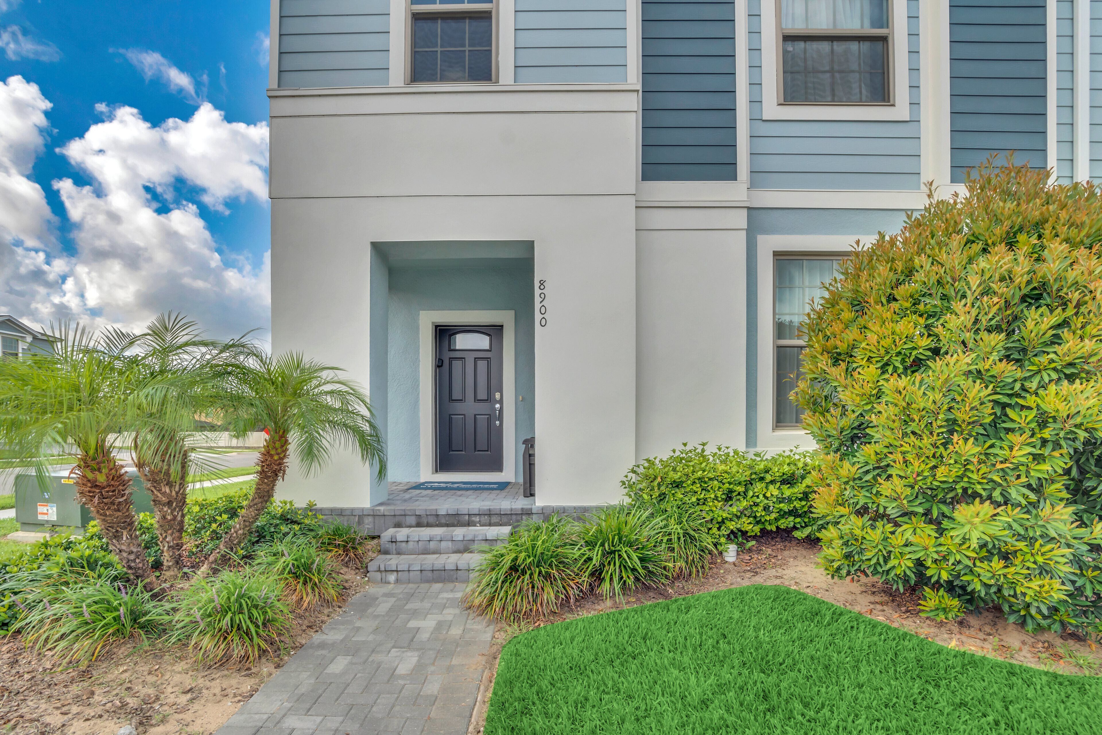 A two-story building with a front door, number 8900, and a small porch area.