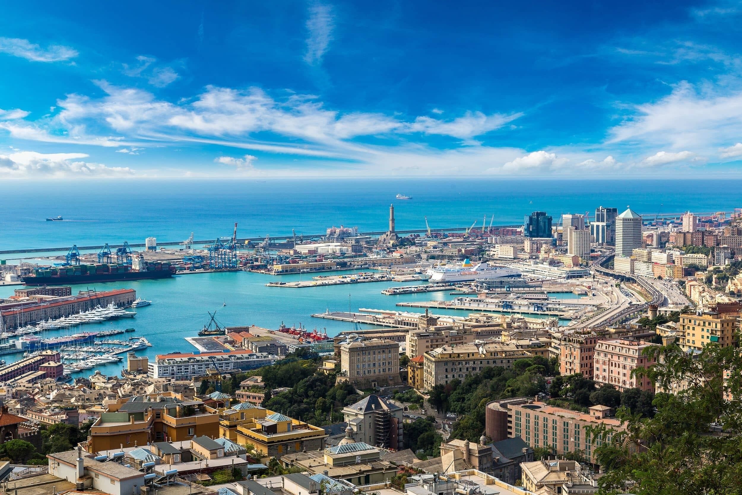 Un paysage urbain côtier avec un port de plaisance, des bâtiments et un ciel bleu dégagé.