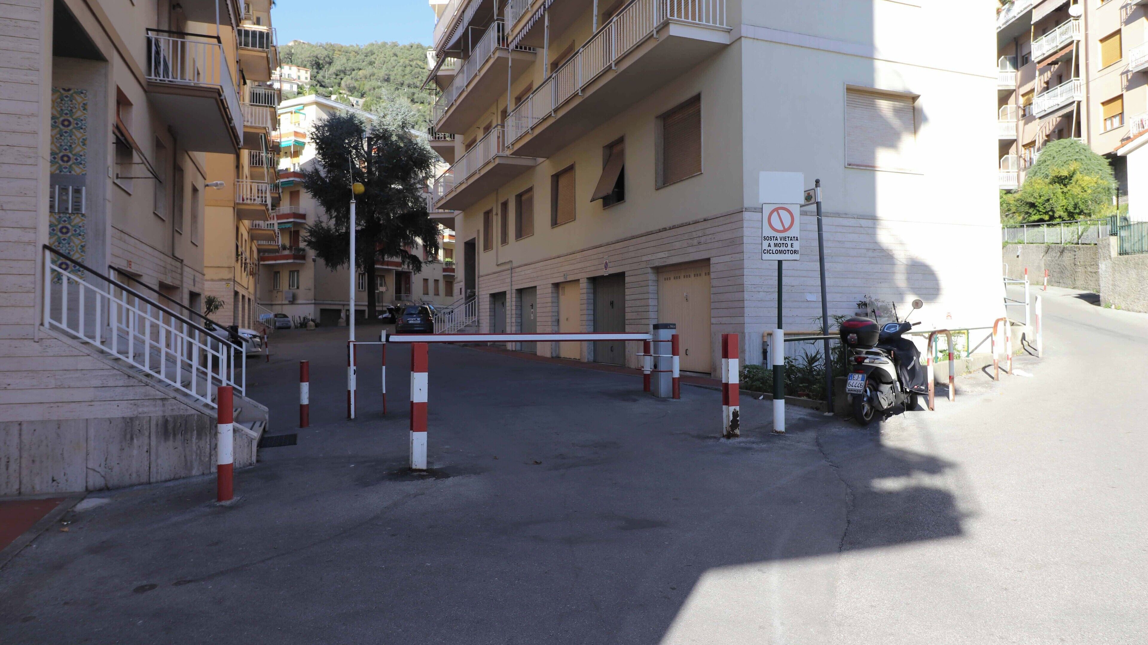 A gated entrance to a residential building with a no-entry sign for vehicles and bicycles.