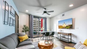 Una sala de estar moderna con sofá, mesa de centro y comedor.
