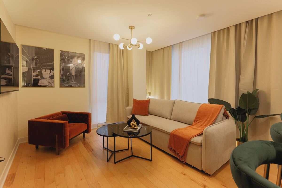 Un salon comprenant un canapé, un fauteuil, une table basse et un lustre.