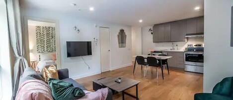 Una sala de estar moderna con un sofá, una mesa de centro y un comedor con sillas y una mesa.
