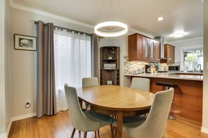 Une cuisine moderne avec des meubles en bois, une table à manger avec des chaises et un îlot de cuisine.