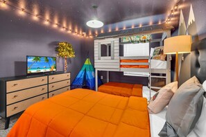 A bedroom with a bunk bed, a dresser, a television, and string lights. - Last Minute Disney! Private Pool, Hot Tub, Game Room & Themed Bedrooms. Book Now! #92373 (Orlando)