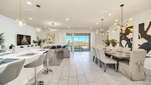 Una cocina moderna con comedor, ventanas amplias y decoración contemporánea.