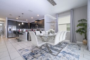 Una cocina moderna con gabinetes oscuros, electrodomésticos de acero inoxidable y una isla central con asientos.