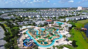 Un resort con una gran piscina, toboganes acuáticos y un campo de golf.